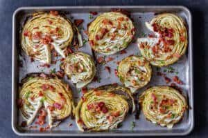crispy roasted cabbage steaks on a pan with bacon