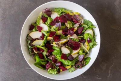 green leaves, pear and beets in a bowl