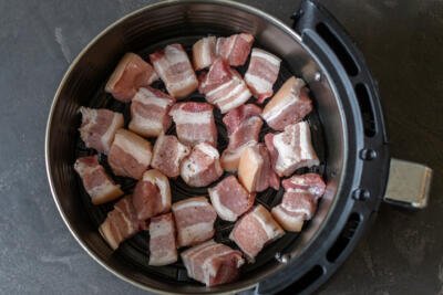 Pork belly bites in an air fryer basket