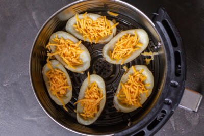 Potato skins with cheese in an air fryer basket