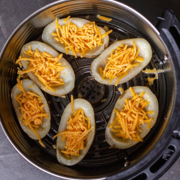 Potato skins with cheese in an air fryer basket