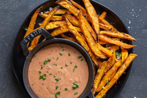 Sweet potato fries on a plate with sauce