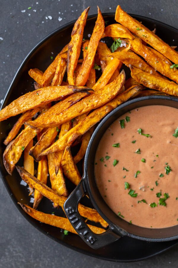 Sweet potato fries on a plate with sauce