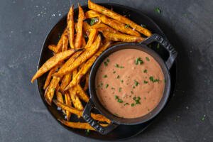Sweet potato fries on a plate with sauce