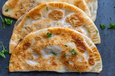 Chebureki with herbs on a counter