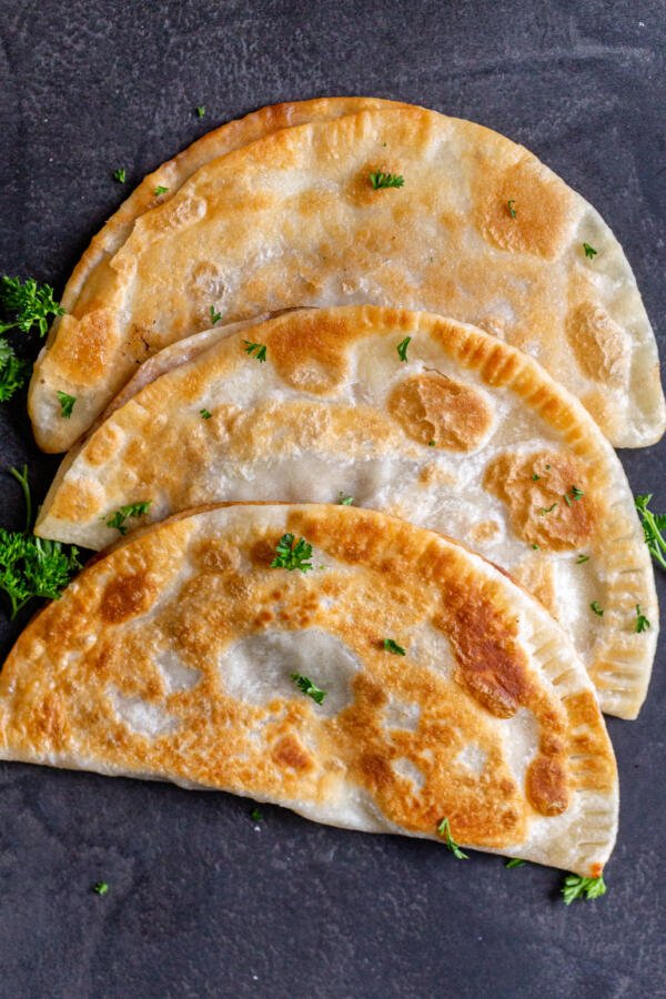 Chebureki with herbs on a counter