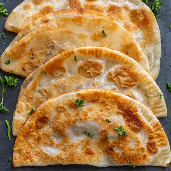 Chebureki with herbs on a counter