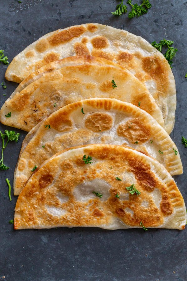 Chebureki with herbs on a counter