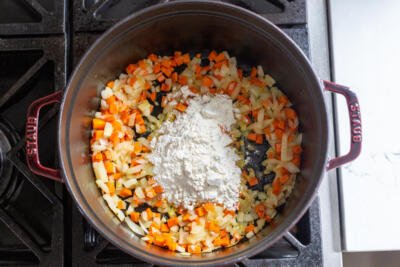 sauteed onions and carrots with flour in the pot