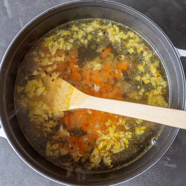 Soup liquid with veggies in a pot