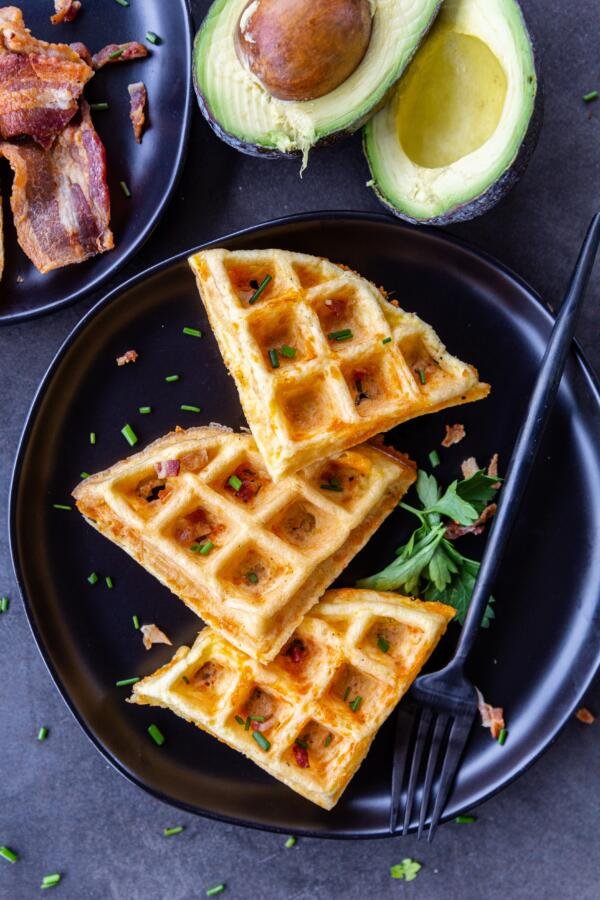 prepared chaffles on a plate with herbs and bacon