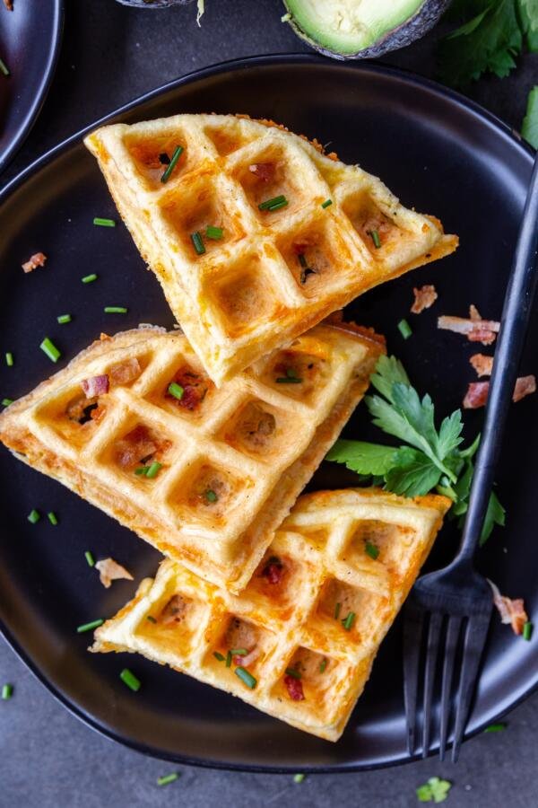 prepared chaffles on a plate with herbs and bacon