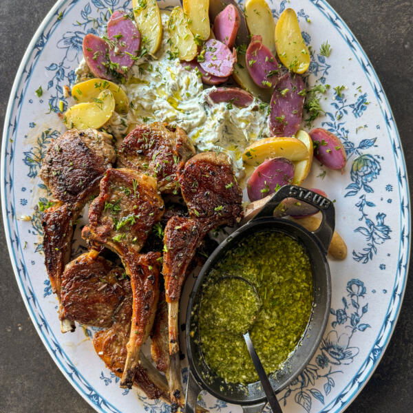 Plated Pan-Fried Lamb Chops with potatoes and sauces.
