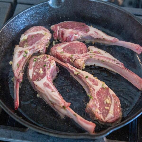 lamb chops frying in a pan