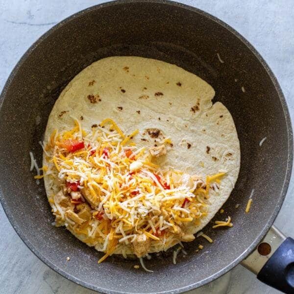 tortilla with cheese and chicken on a pan
