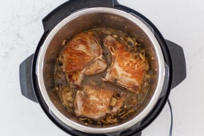 Pork chops added to the mushrooms in an instant pot
