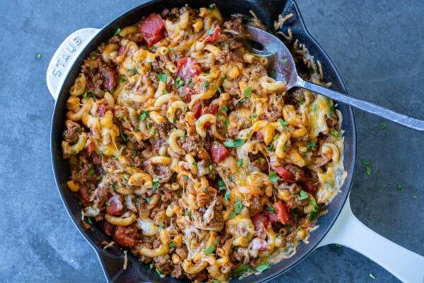 Goulash in a cooking pan with melted cheese