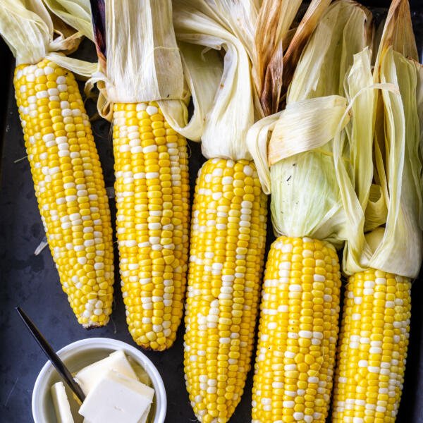 grilled corn on a tray with butter