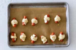 pigs in a blanket on a baking sheet with sesame seeds