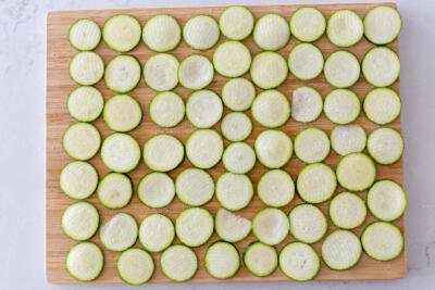 Salted zucchini pieces on a cutting board