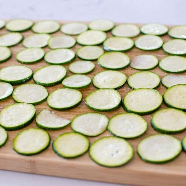Salted zucchini pieces on a cutting board