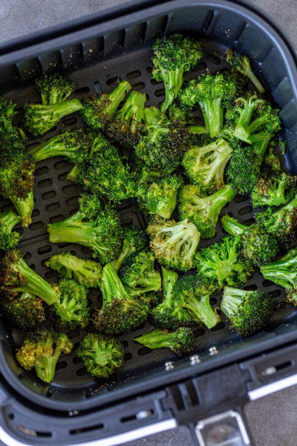 Air fryer broccoli in an air fryer basket 