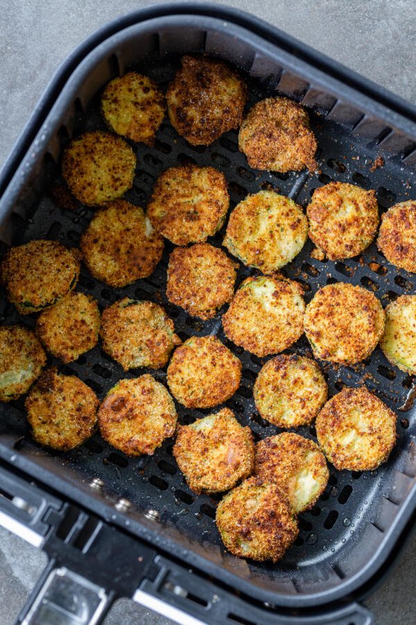 parmesan zucchini chips in air fryer basket cooked