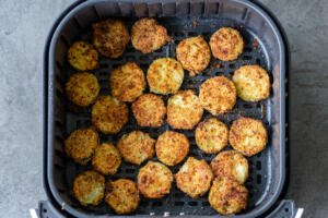 parmesan zucchini chips in air fryer basket cooked