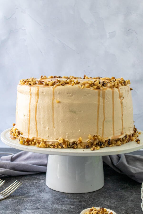 A honey walnut poppy seed cake on a stand 