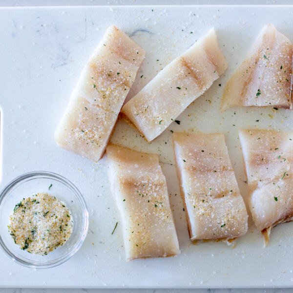 seasoned halibut on a cutting board