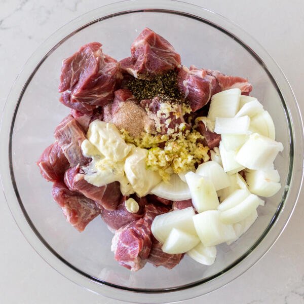 Pork with mayo seasoning and onion in a bowl