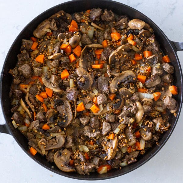 liquids added to buckwheat stew in a pan