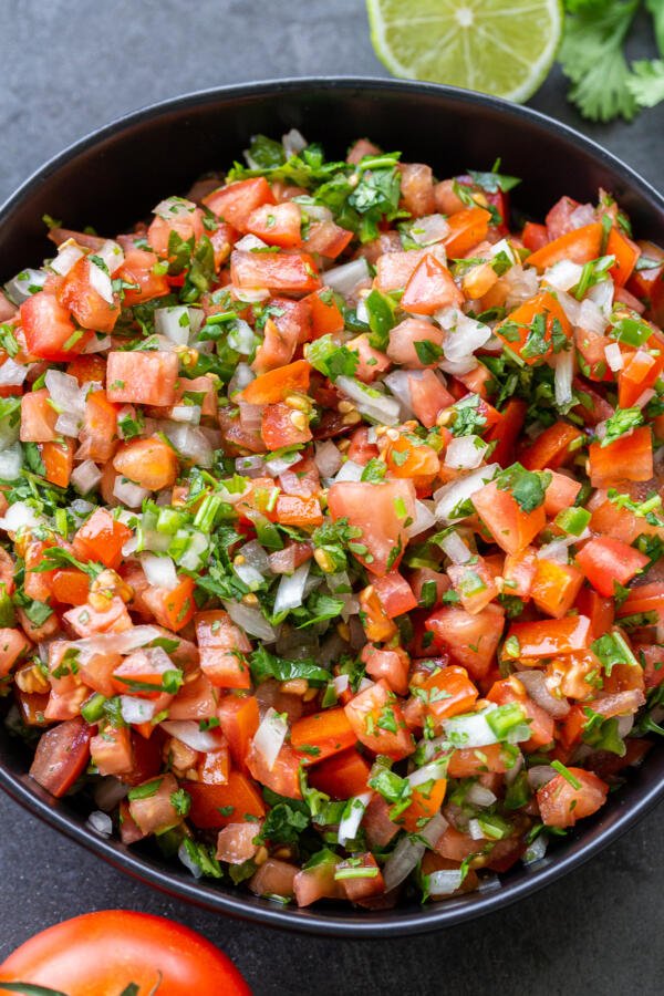  The Classic Pico de Gallo in a bowl with vegetables next to it 