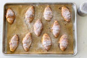 croissants with powdered sugar on a baking sheet