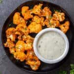 cooked cauliflower with buffalo sauce on a plate