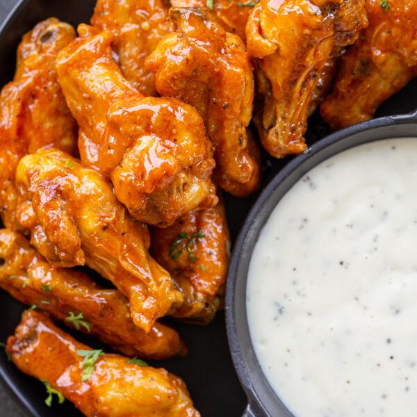 air fryer wing with buffalo sauce on a plate with ranch for dipping