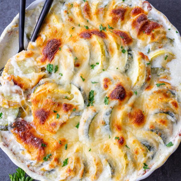 Cheesy Zucchini and Squash Casserole in a baking pan with a spoon