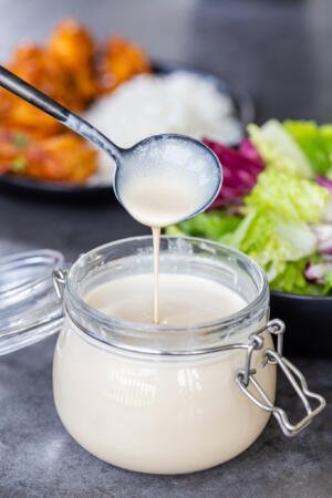China Coast Salad dressing in a jar with a spoon dripping it