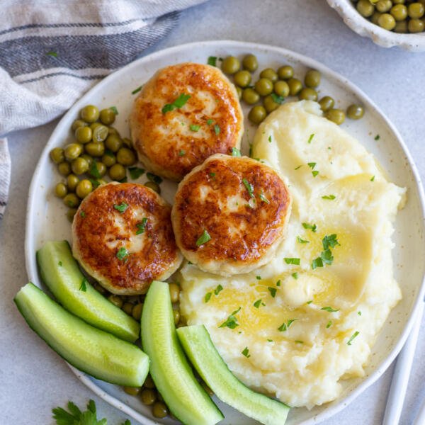 Kotleti on a palte with cucumbers and mashed potatoes