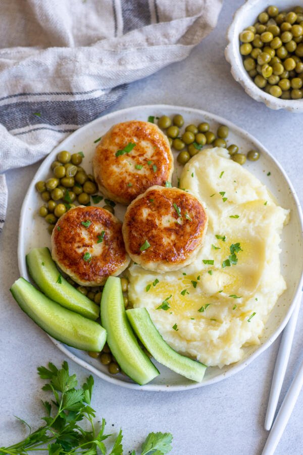 Kotleti on a palte with cucumbers and mashed potatoes