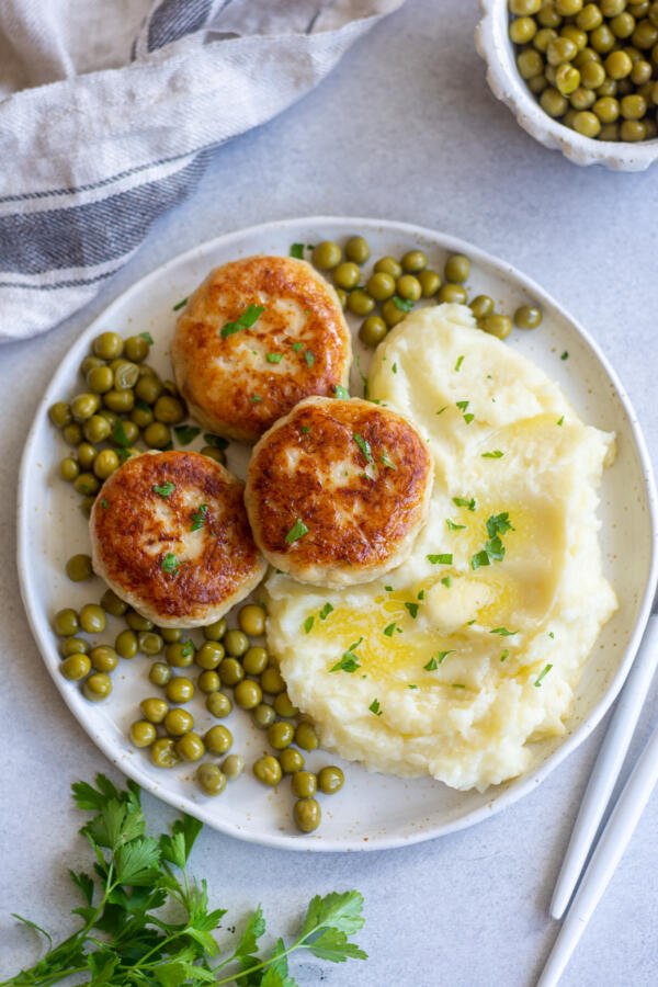 Kotleti on a palte with cucumbers and mashed potatoes