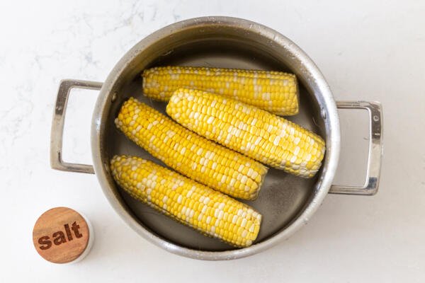corn on a cob in a pot with salt and water