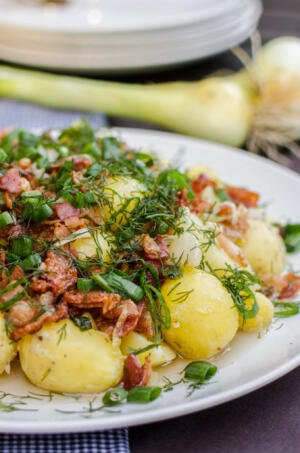 New potatoes on a plate with herbs and bacon