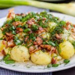 New potatoes on a plate with herbs and bacon