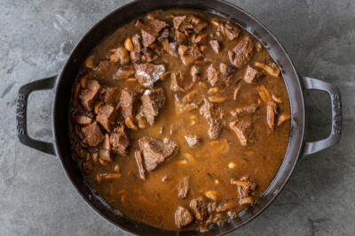 beef in a liquid in a pan