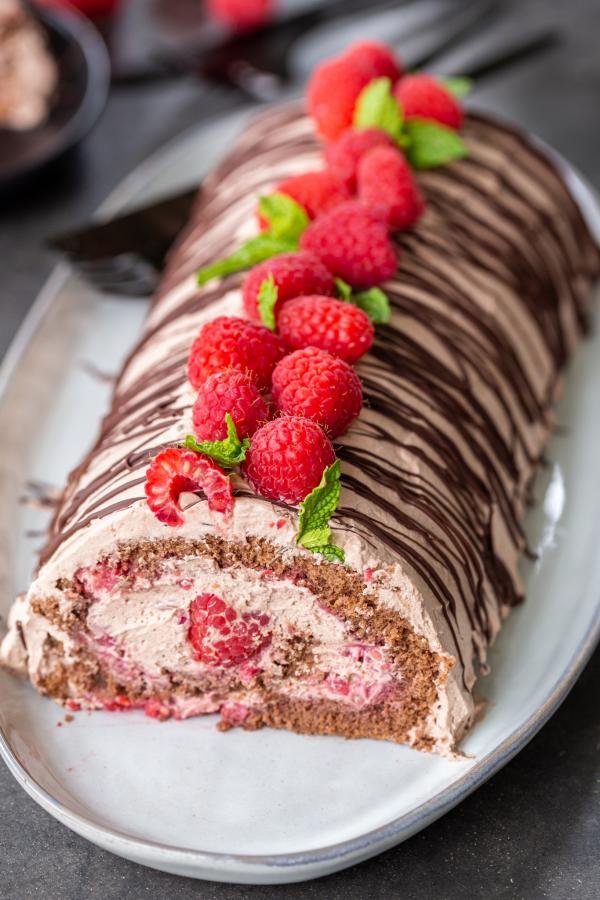 Raspberry chocolate cake roll on a plate. 