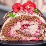 A slice of Raspberry chocolate cake roll on a plate.