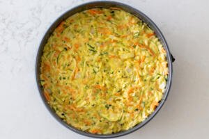 All the zucchini casserole ingredients in a pan