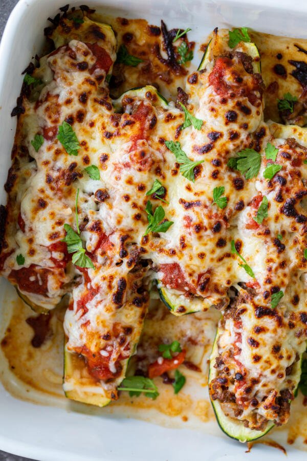 Stuffed Zucchini Boats in a baking dish with herbs