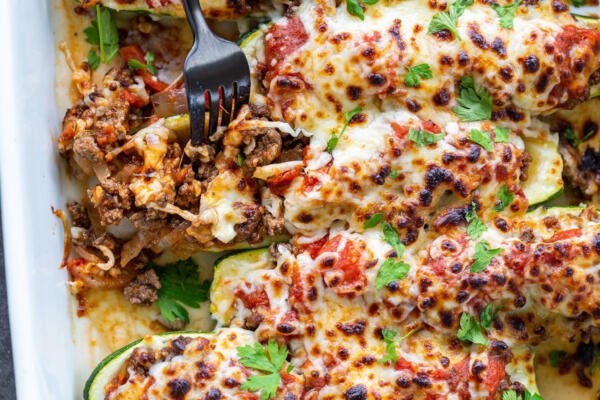 Stuffed Zucchini Boats in a baking dish with herbs